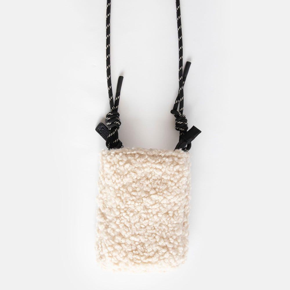 synthetic cream borg phone bag with a monochrome adjustable cord strap and black zip pull