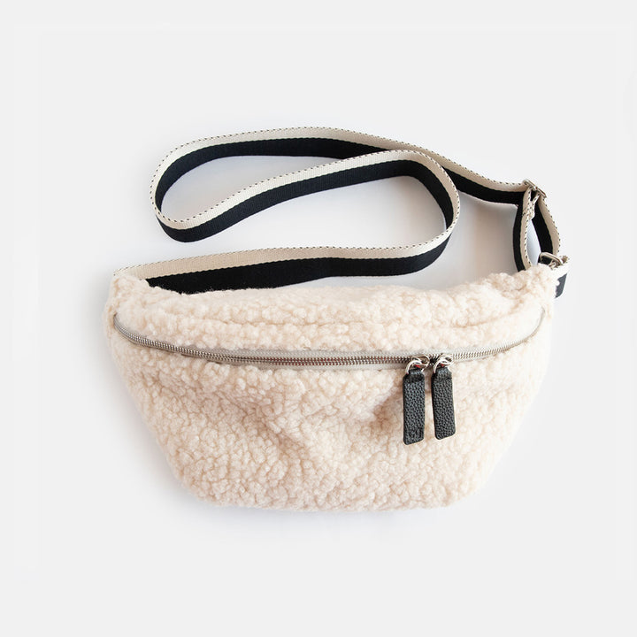 synthetic cream borg crossbody bag with a monochrome strap, black zip pulls and big spots print lining