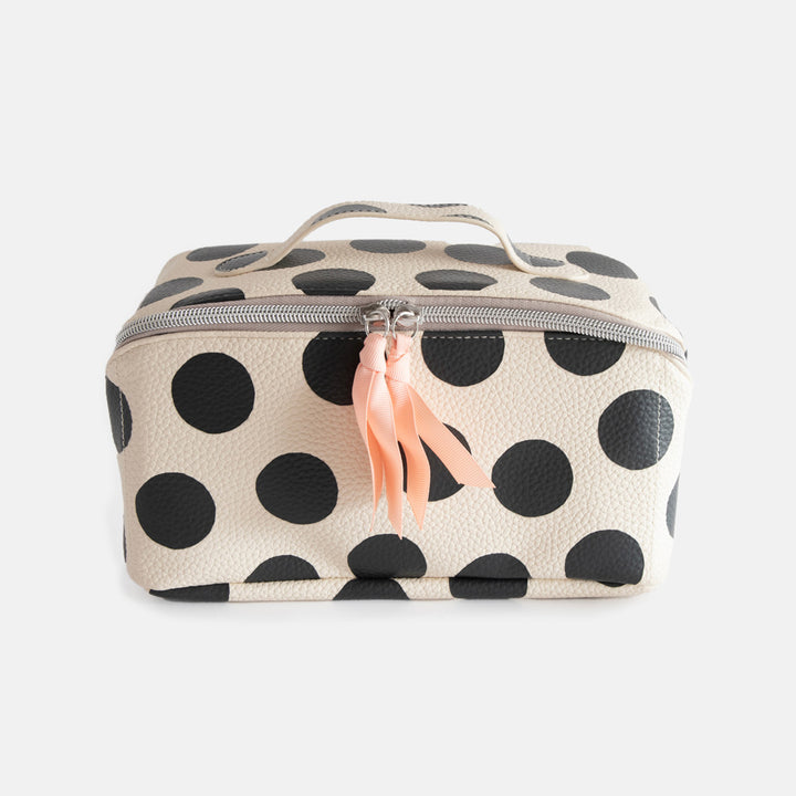 diagonal zip flat lay vegan leather wash bag in monochrome spots with top handle, silver zip and soft pink grosgrain pull