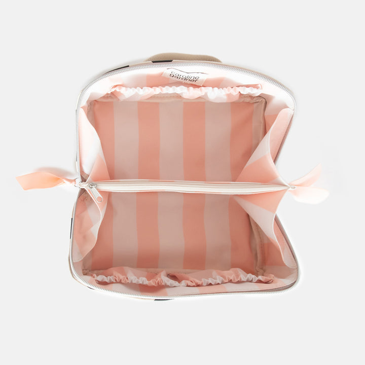 diagonal zip flat lay vegan leather wash bag in monochrome spots with soft pink striped lining and inner zipped pocket