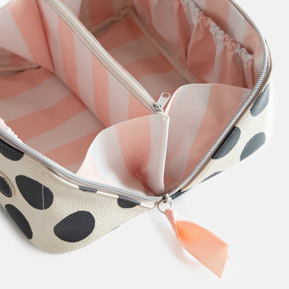 diagonal zip flat lay vegan leather wash bag in monochrome spots with soft pink striped lining and inner zipped pocket