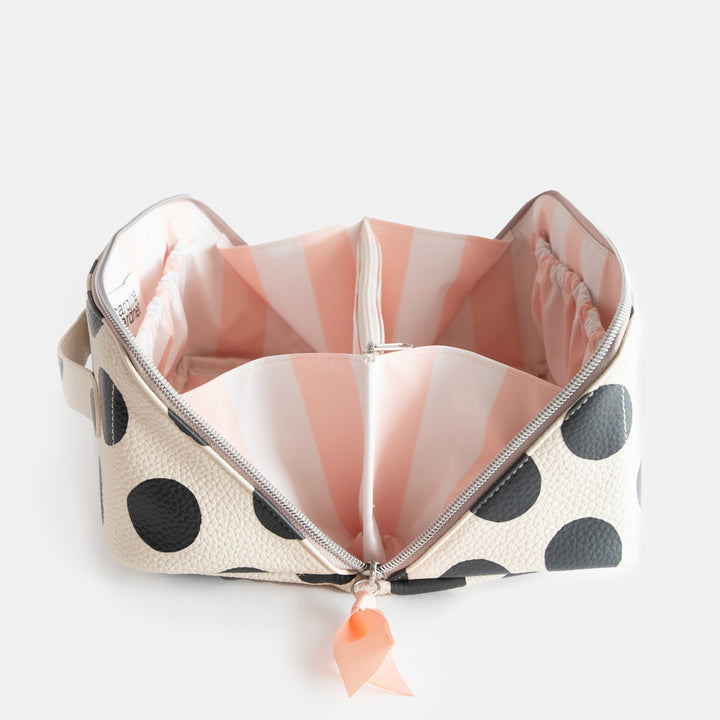 diagonal zip flat lay vegan leather wash bag in monochrome spots with soft pink striped lining and inner zipped pocket