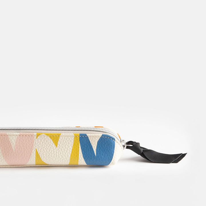 leather look PU slim pencil case in a multicolour hearts design with a black ribbon zip pull and pink striped lining
