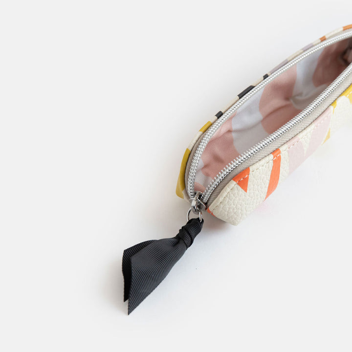leather look PU slim pencil case in a multicolour hearts design with a black ribbon zip pull and pink striped lining