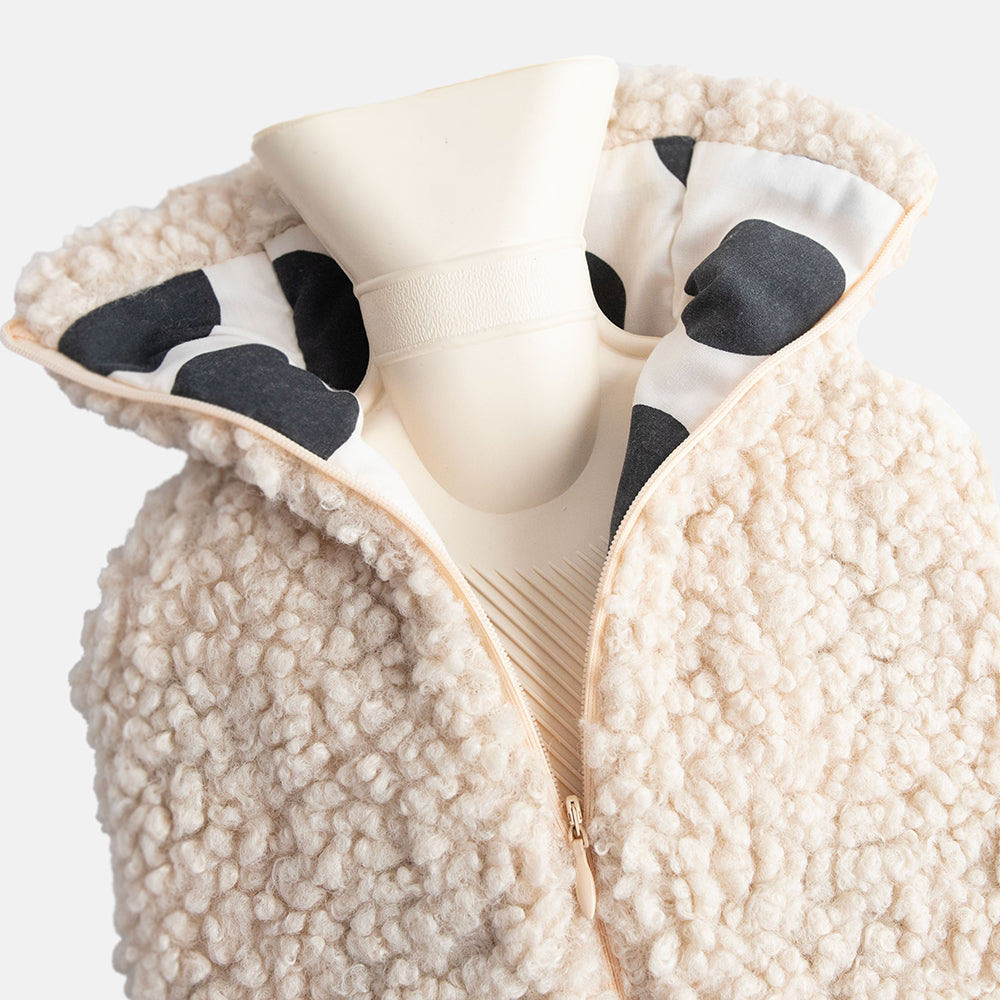 Close-up of a oatmeal borg hot water bottle with black and white polka dot lining