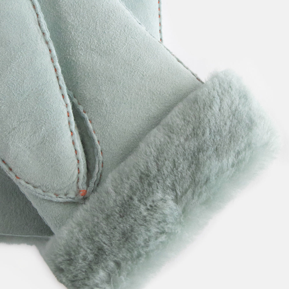women's sheepskin shearling gloves in light blue, folded back at the wrist to show light blue lining