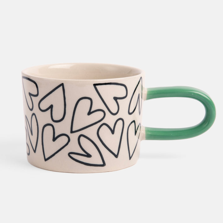 monochrome hearts hand painted stoneware mug with contrast green handle