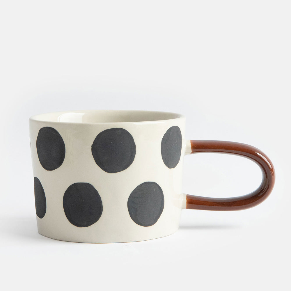 hand painted ceramic stoneware mug with big black dots design and a brown elongated handle