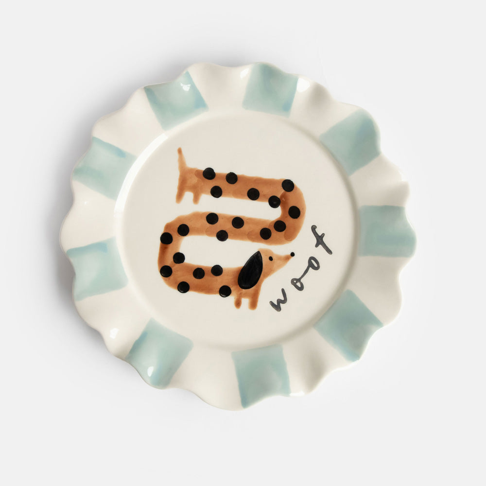 hand painted ceramic stoneware plate with light blue stripe scalloped edge, sausage dog design and 'woof' slogan
