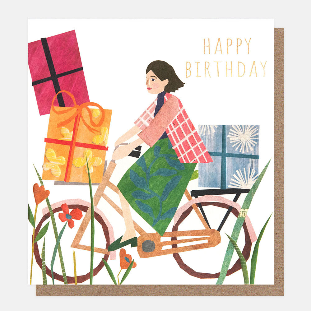 woman cycling on a bike with presents stacked up happy birthday card