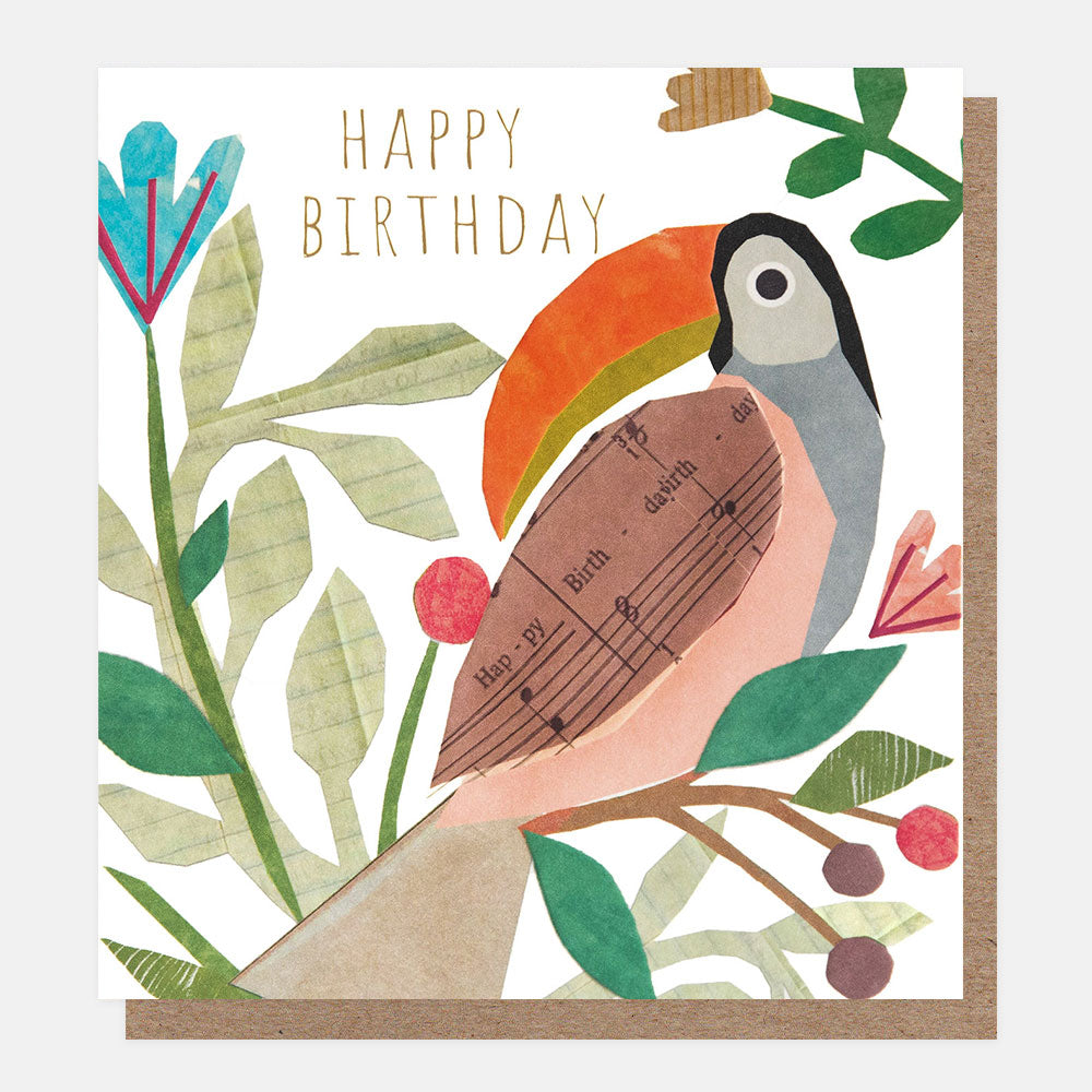 birthday card with toucan sat in a tree with a happy birthday sheet music wing