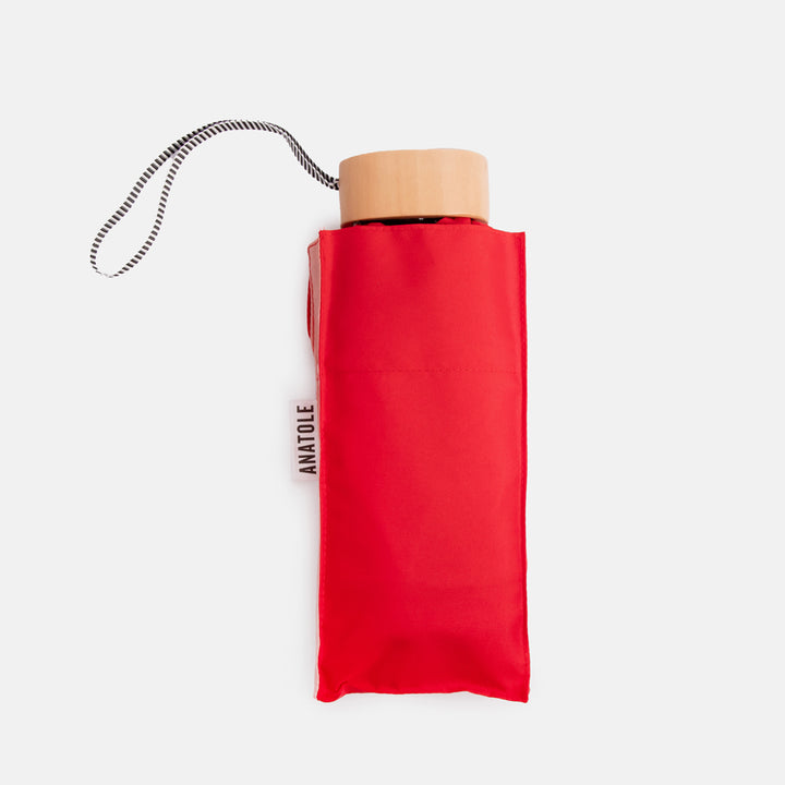half red half pink folding compact umbrella with wooden handle and a monochrome strap