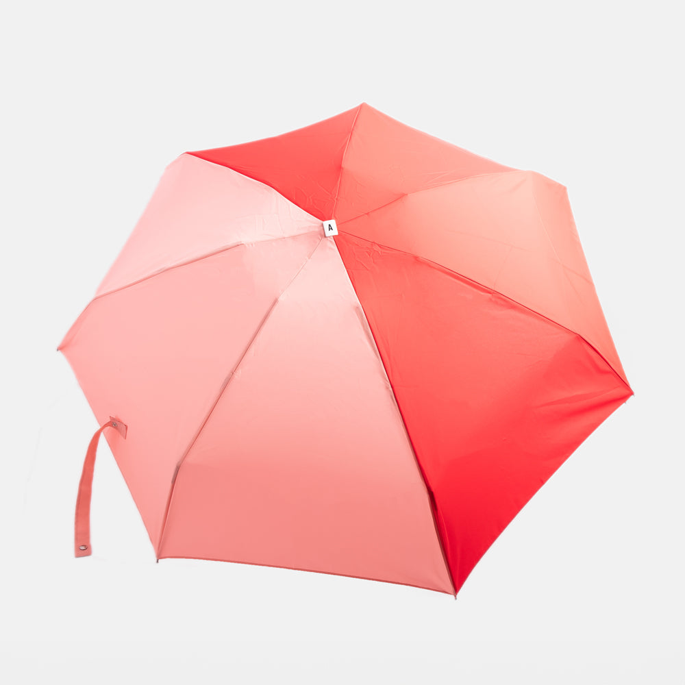 red & pink folding compact umbrella with wooden handle and a monochrome strap