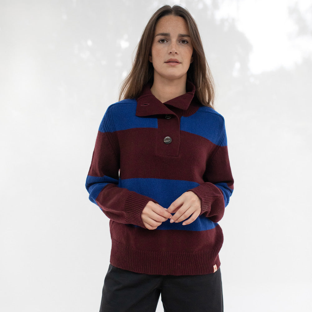 Person wearing a maroon and blue sweater against a white background