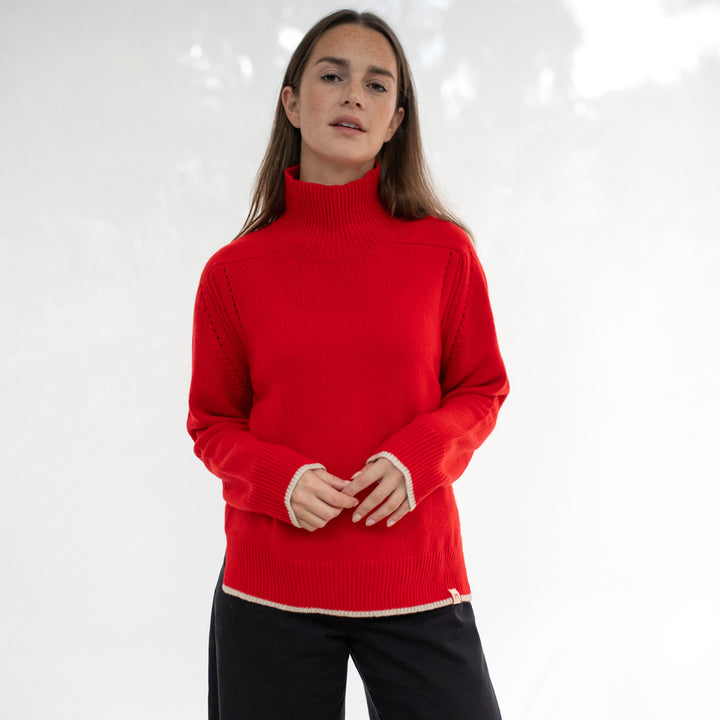 Person wearing a red turtleneck sweater on a white background