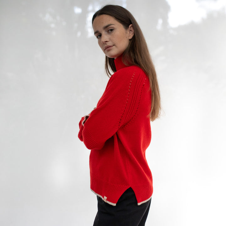 Woman wearing a red sweater with a white background