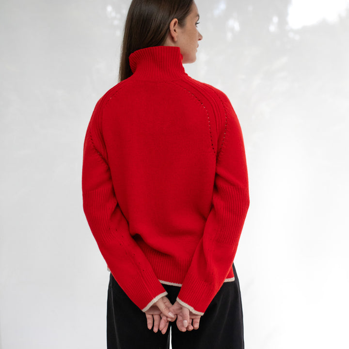 Person wearing a red sweater against a white background