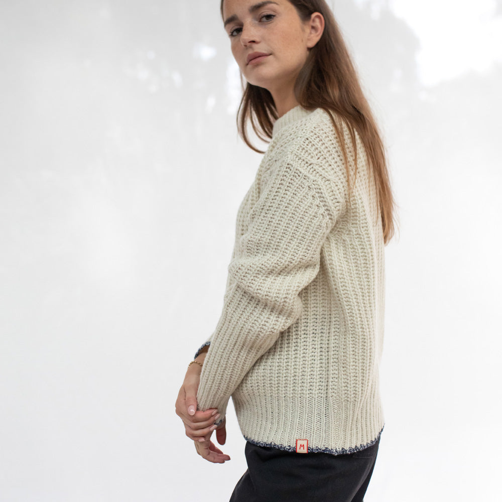 Woman wearing a beige knitted sweater on a white background