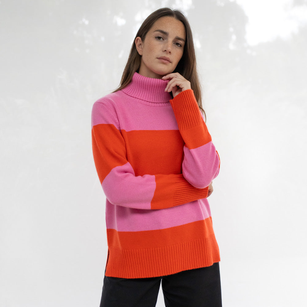 Woman wearing a pink and orange striped sweater on a white background