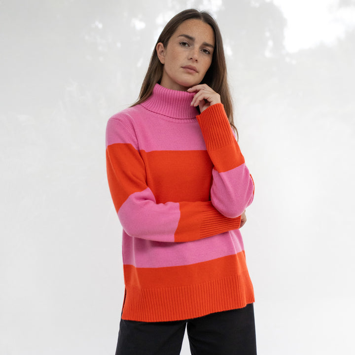 Woman wearing a pink and orange striped sweater on a white background