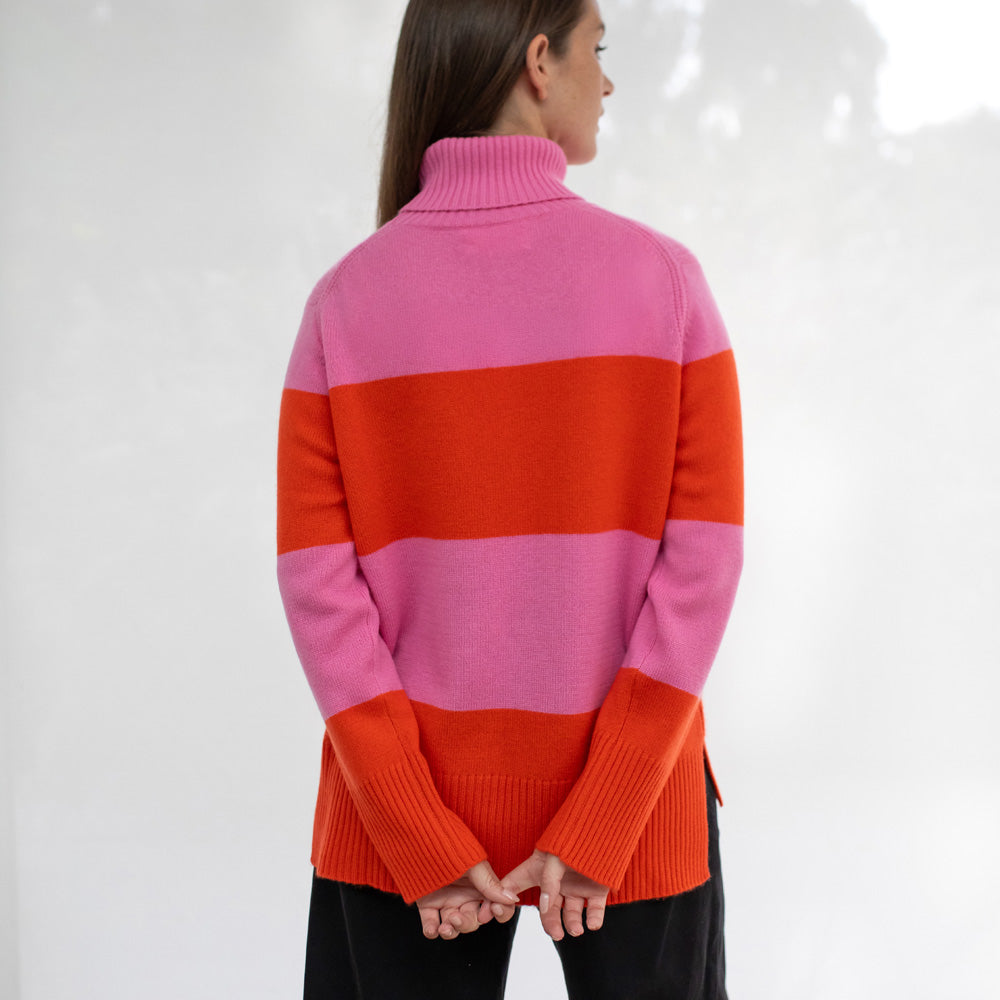 Person wearing a pink and orange striped sweater on a white background