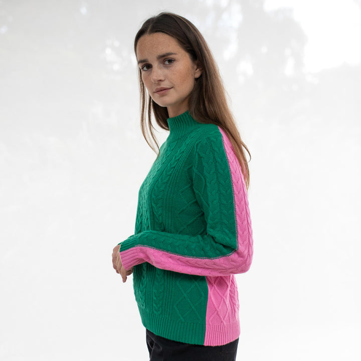 Woman wearing a green and pink sweater against a white background