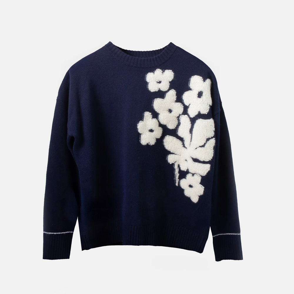 Navy sweater with white floral patterns on a light gray background