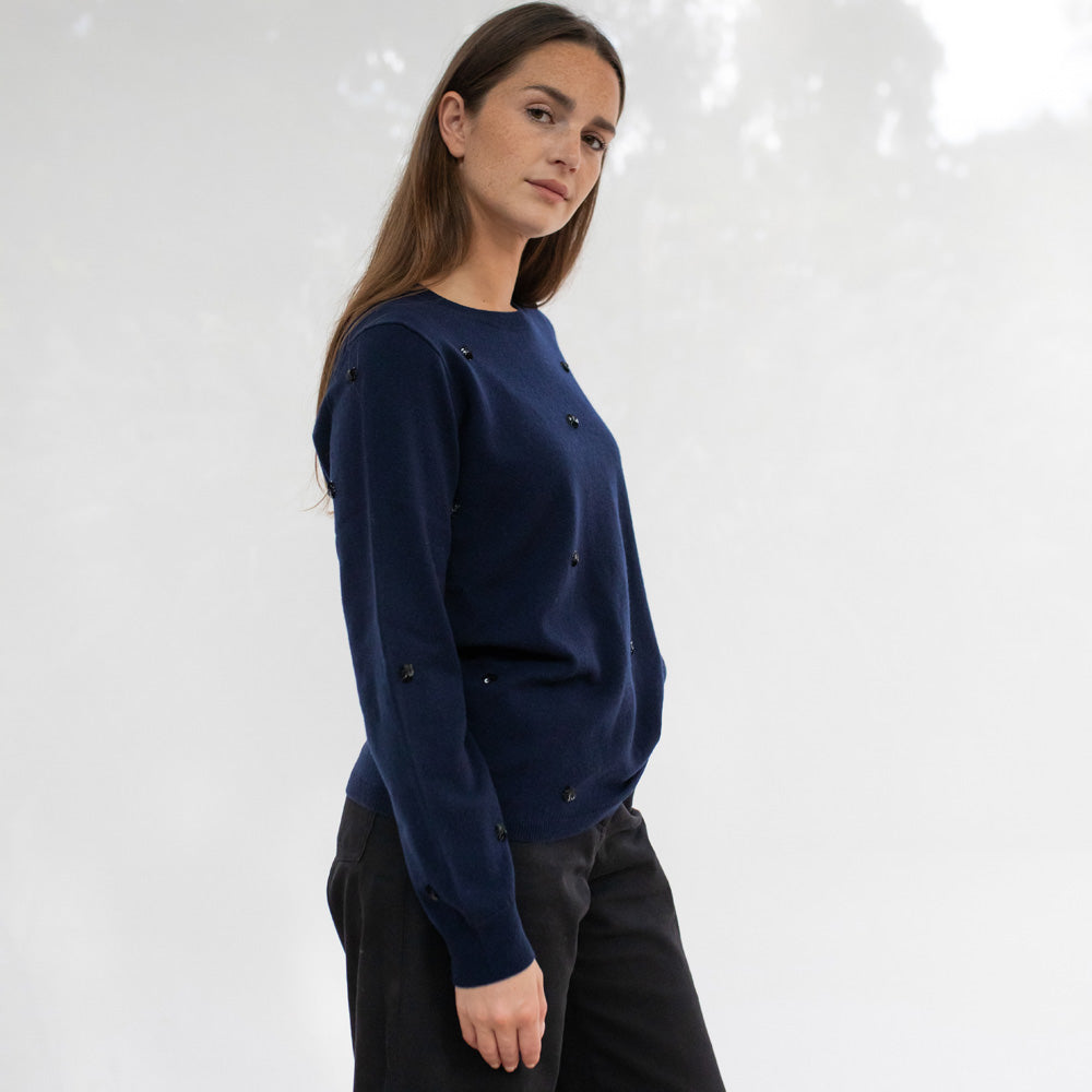 Woman wearing a navy blue sweater against a white background