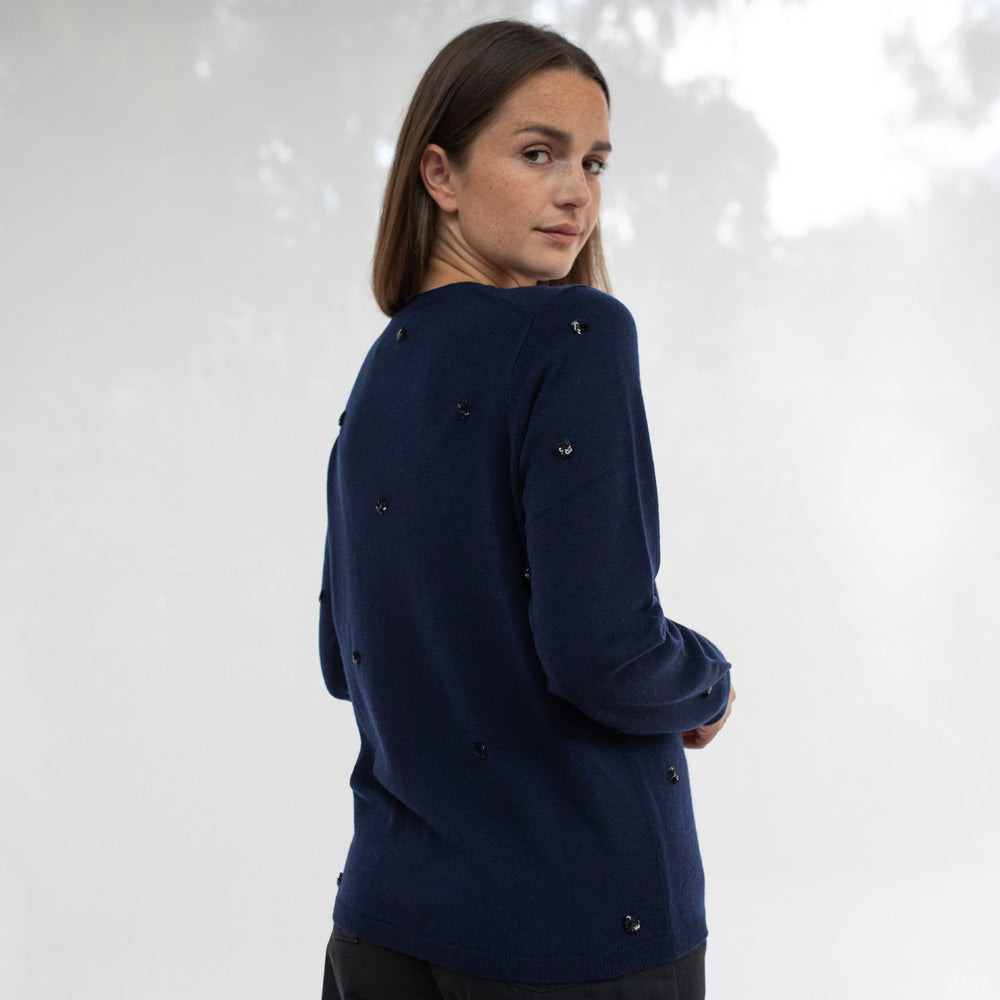 Woman wearing a navy blue jacket against a white background