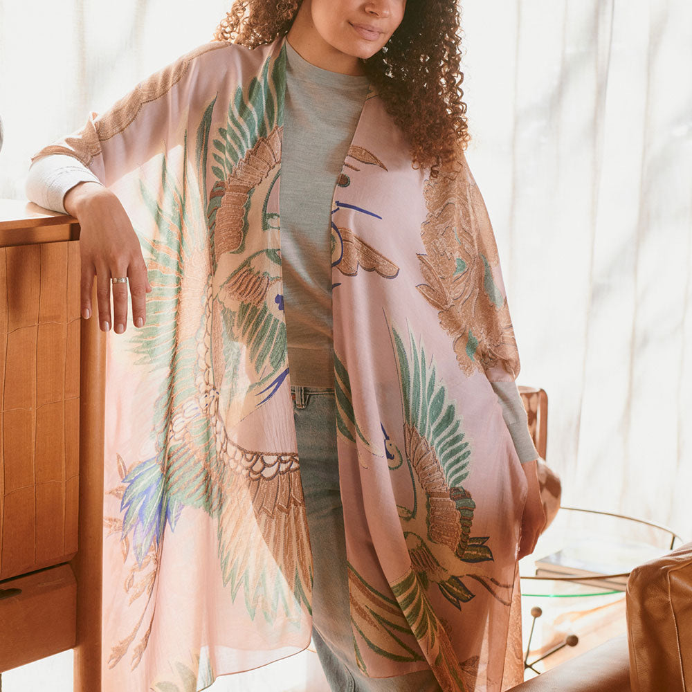 women's throwover top featuring design of cranes in green, brown & blue on a pale pink base