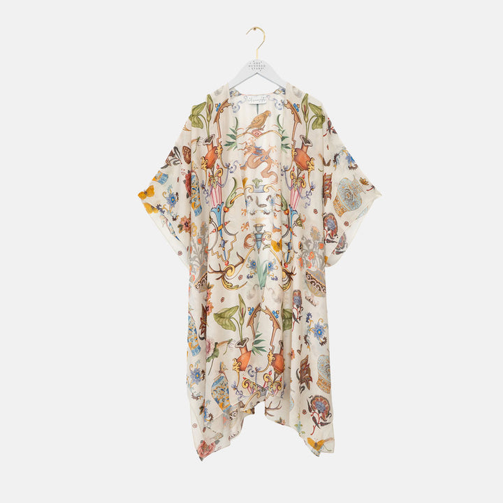 women's throwover top featuring a design of assorted objects, animals and flowers on an off white background
