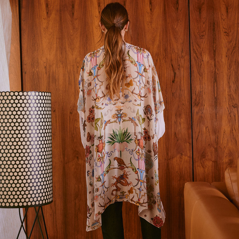 women's throwover top featuring a design of assorted objects, animals and flowers on an off white background