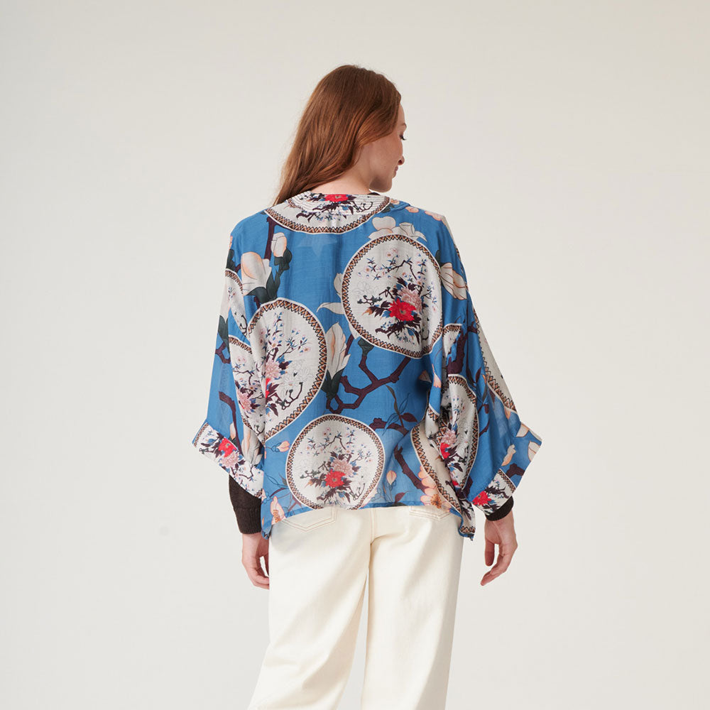 women's short kimono with print of decorative floral plates and white magnolia on a bright blue base