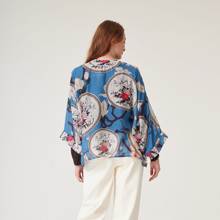 women's short kimono with print of decorative floral plates and white magnolia on a bright blue base