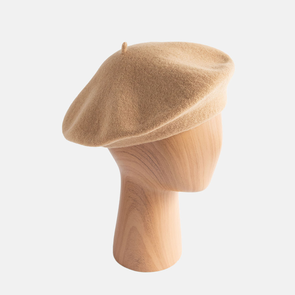camel colour beret on a wooden mannequin
