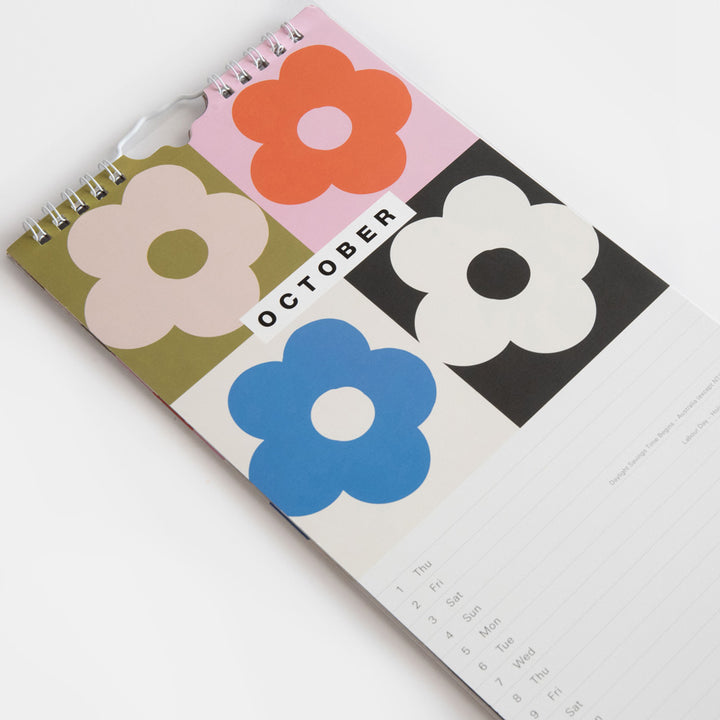 2026 slim wall calendar with October month view page featuring a colourful flower print at the top