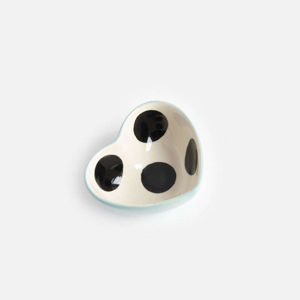 heart shaped hand painted glazed ceramic stoneware trinket bowl qith a black spot inside and light blue outer design