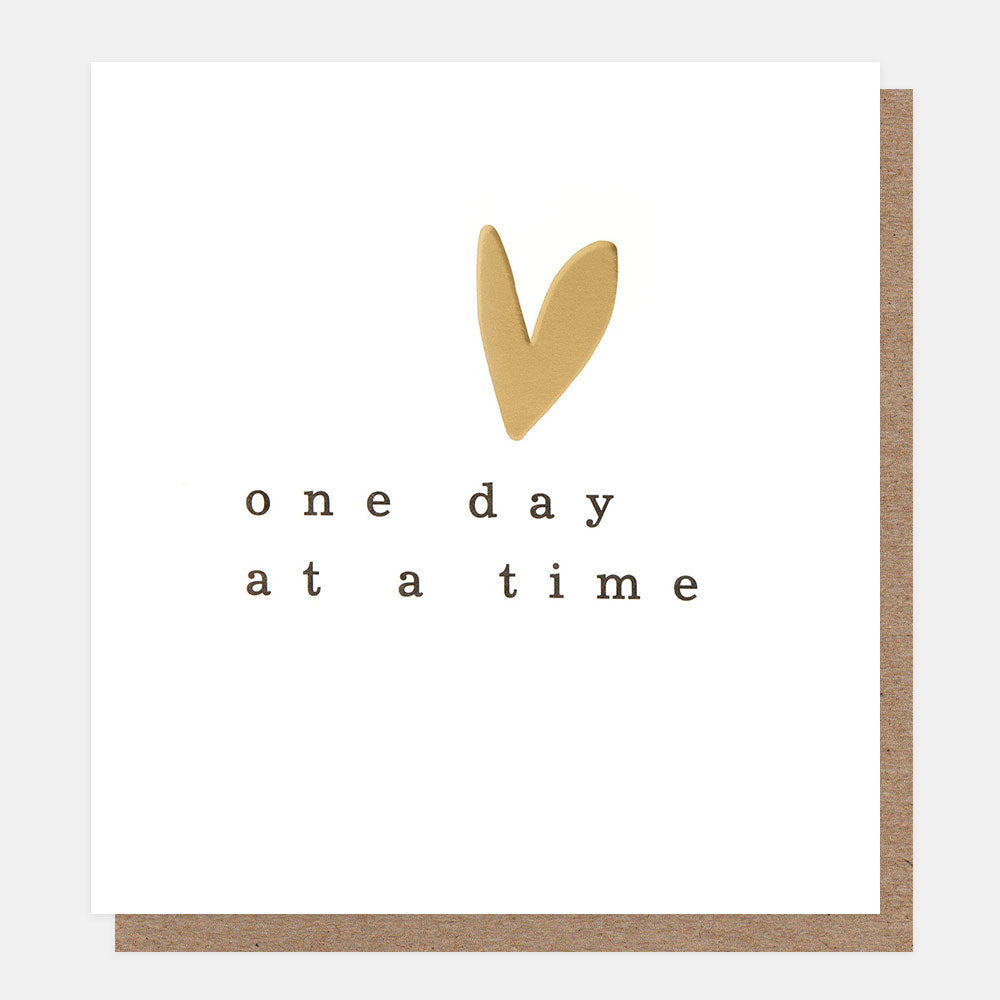 Motivational card with 'one day at a time' text and gold heart on white background