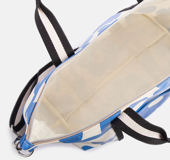 coated cotton canvas weekend bag with blue floral design and monochrome stripe webbing grab handles and detachable shoulder strap
