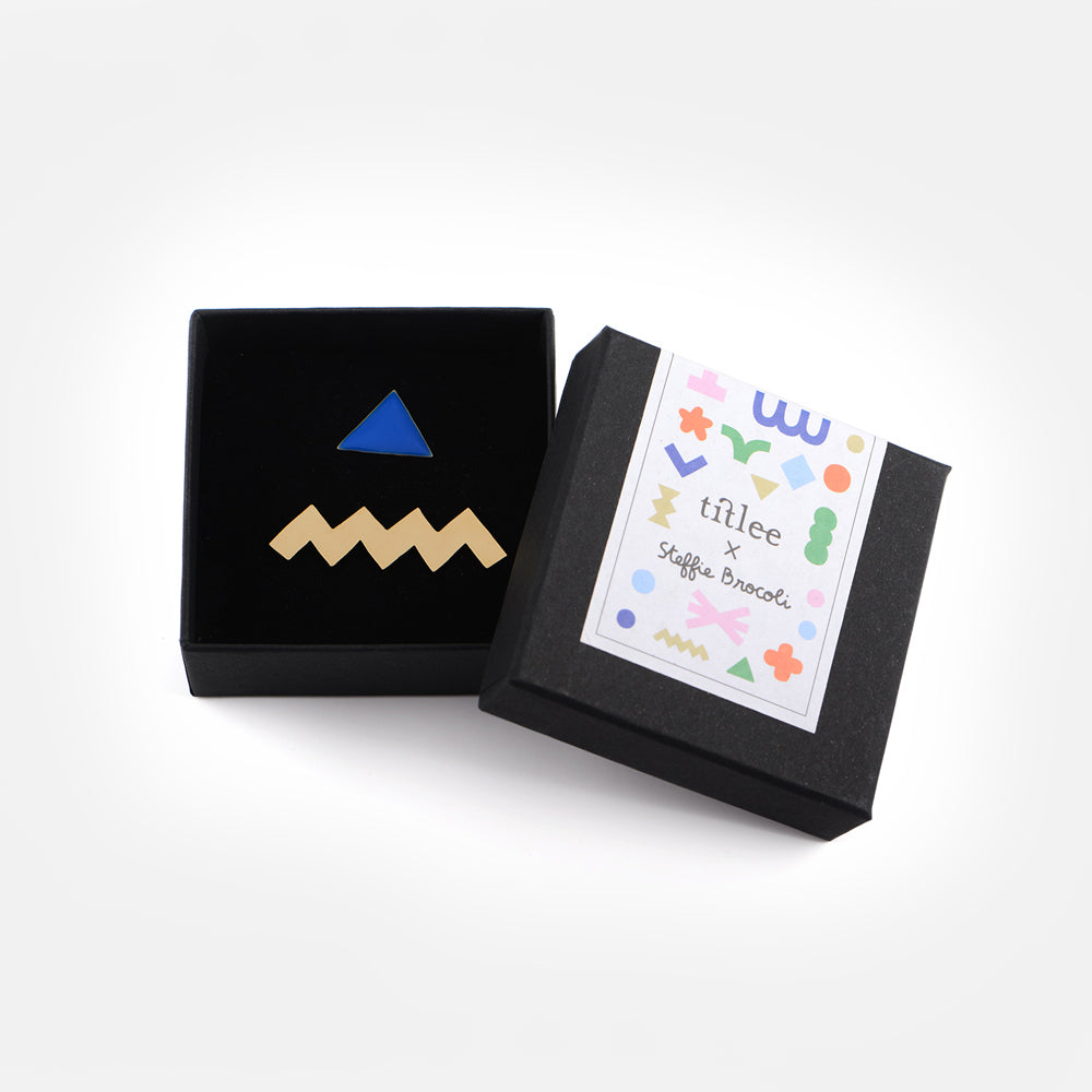 Titlee black presentation boxpair of abstract gold gilded micro brooches/lapel pins, gold zigzag and blue triangle.