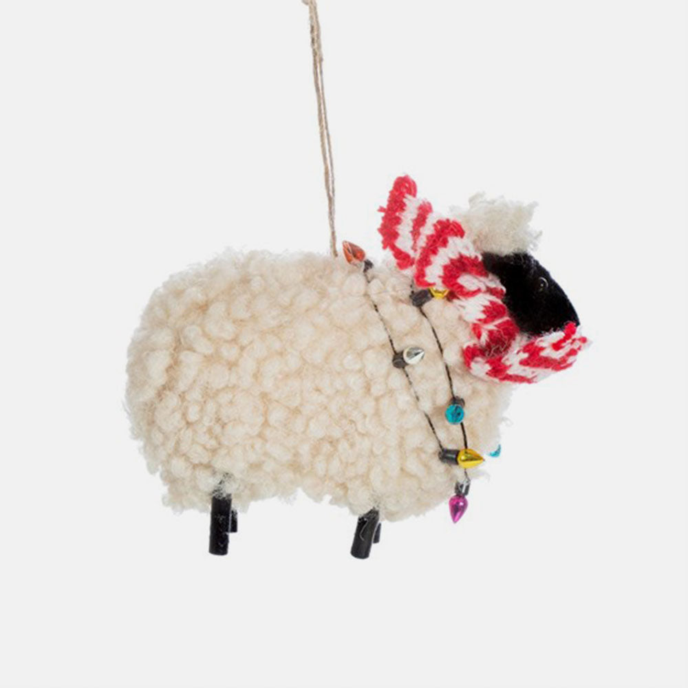 wool sheep in red scarf and fairy lights hanging christmas tree decoration