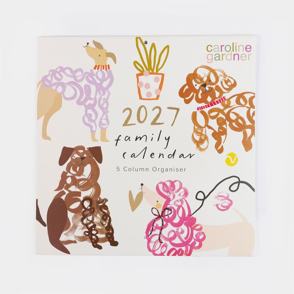 A 2027 family calendar by Caroline Gardner, featuring a cream-colored cover decorated with whimsical, stylized illustrations of dogs in various colors and patterns, along with gold and black text.