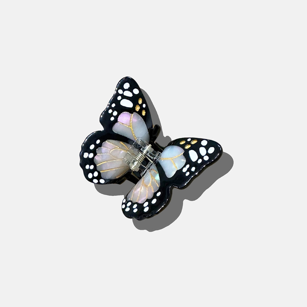 Butterfly-shaped hair clip on a light gray background