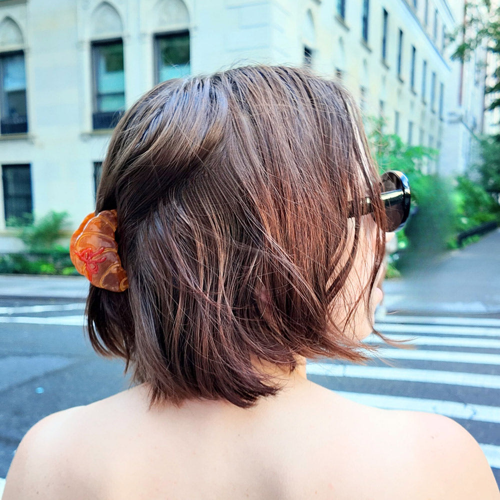 woman with croissant hair claw in hair on a city street