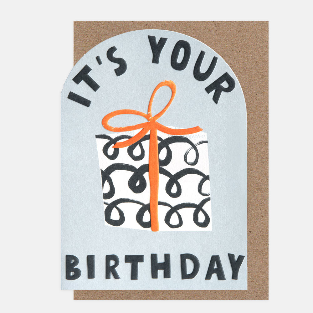 Birthday card with a gift illustration and 'It's Your Birthday' text on a light blue background.