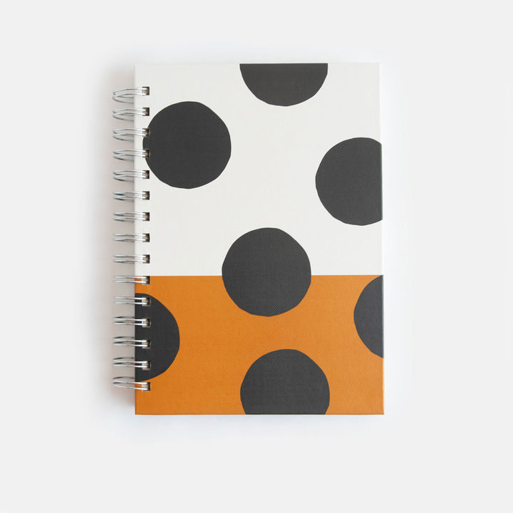 a5 spiral bound hardcover notebook with a big spot print over a cream and tan background design