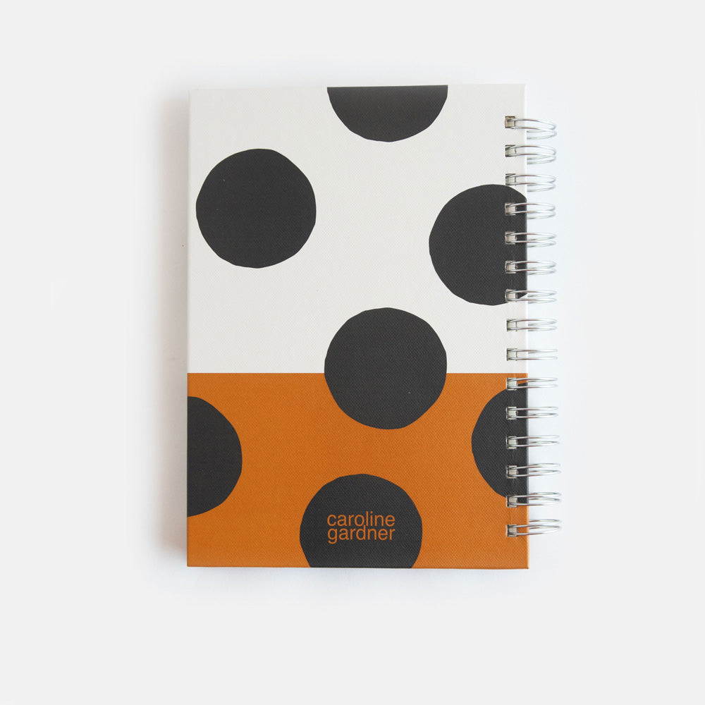 a5 spiral bound hardcover notebook with a big spot print over a cream and tan background design