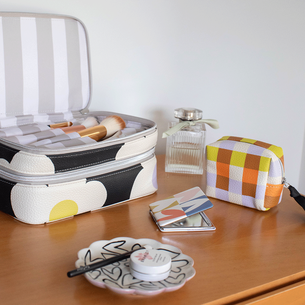 dressing table with make up organiser case, perfume bottle, compact mirror, small cosmetics bag and a trinket tray