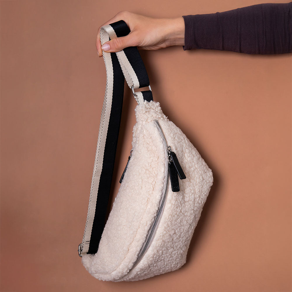 synthetic cream borg crossbody bag with a monochrome strap, black zip pulls and big spots print lining