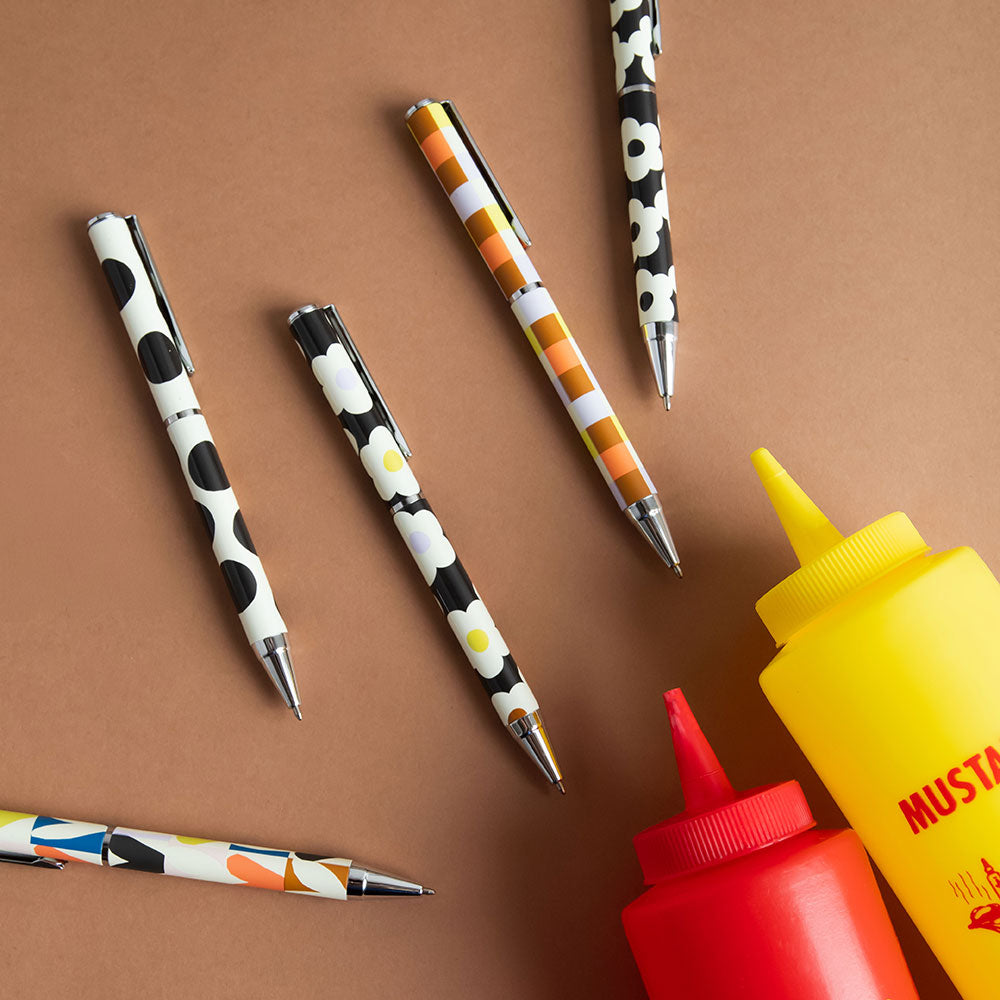 Colorful pens with a mustard and ketchup bottle on a brown background